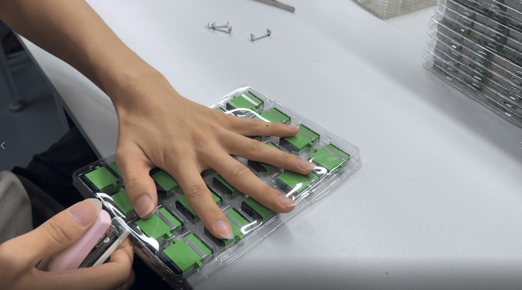 Operator checking adapter packaging during batch assembly