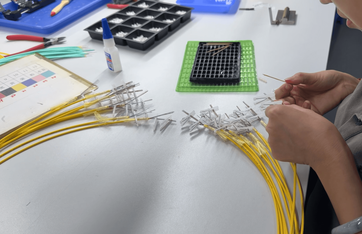 Operator preparing yellow fiber pigtail assemblies at the workbench