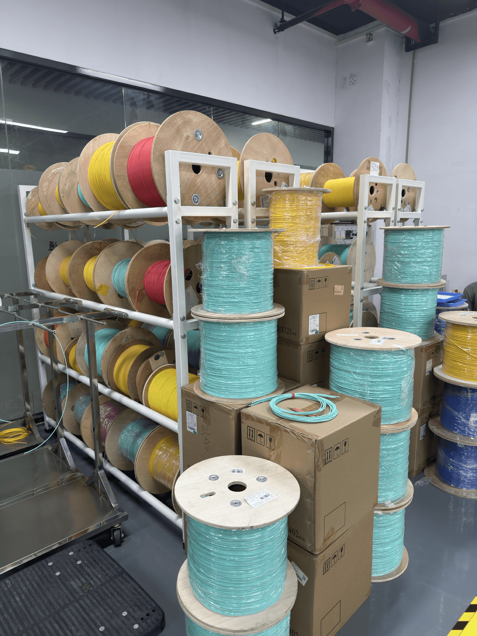 Fiber cable material spools staged on production rack