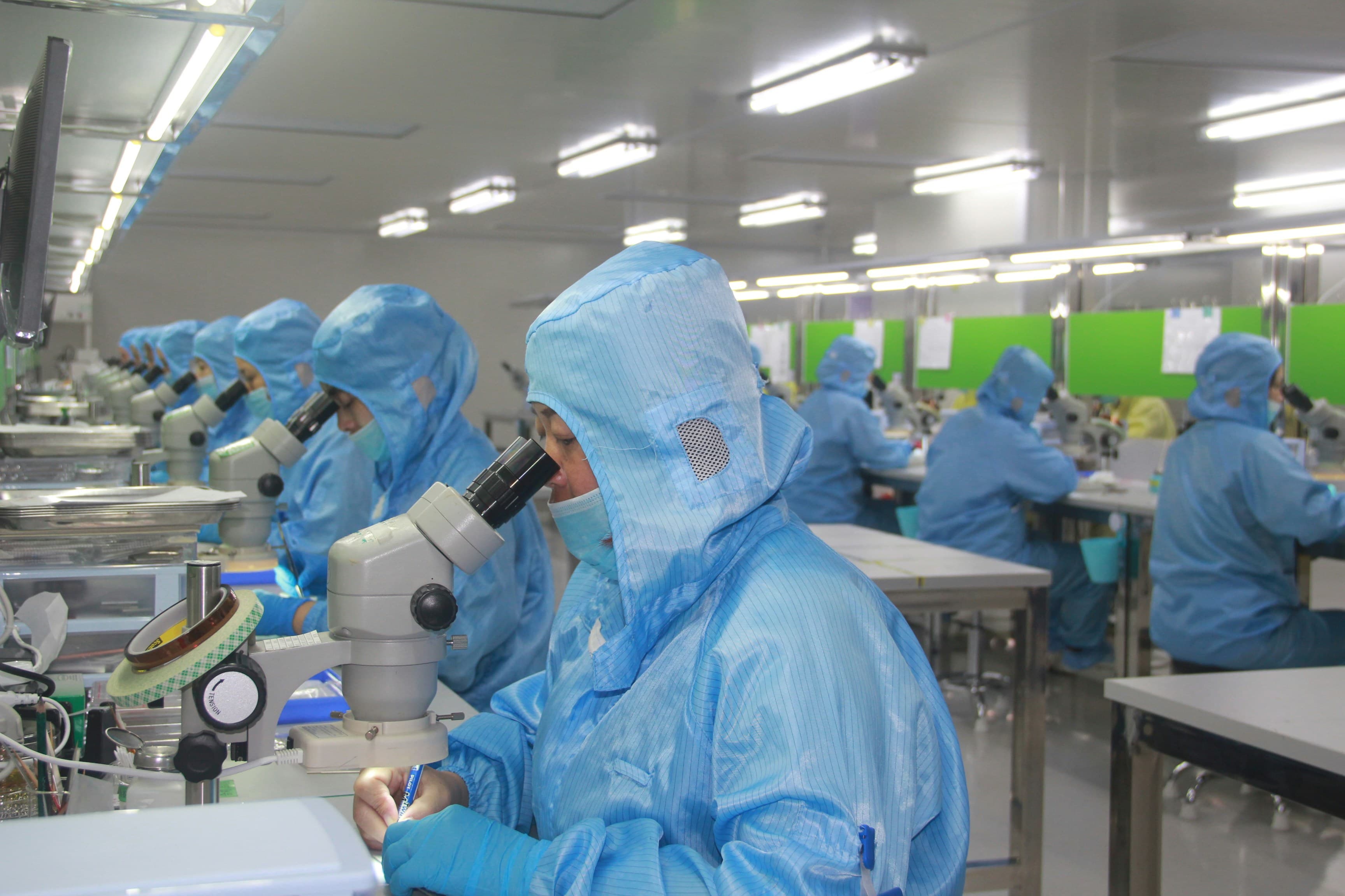 Technicians inspecting fiber components during controlled production